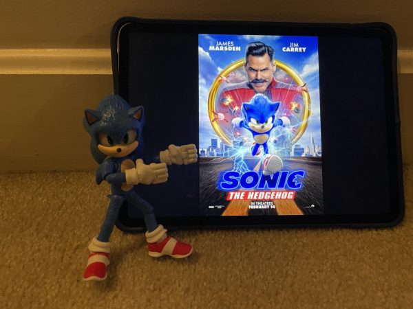 Sonic pointing to the poster for his first movie.