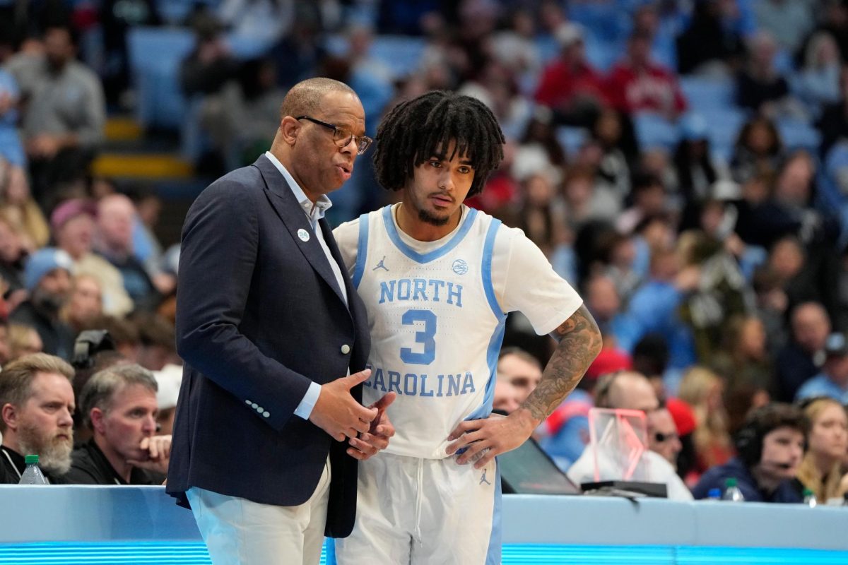 Feb 19, 2025; Chapel Hill, North Carolina, USA; North Carolina Tar Heels head coach Hubert Davis talks with guard Elliot Cadeau (3) in the second half at Dean E. Smith Center. Mandatory Credit: Bob Donnan-Imagn Images