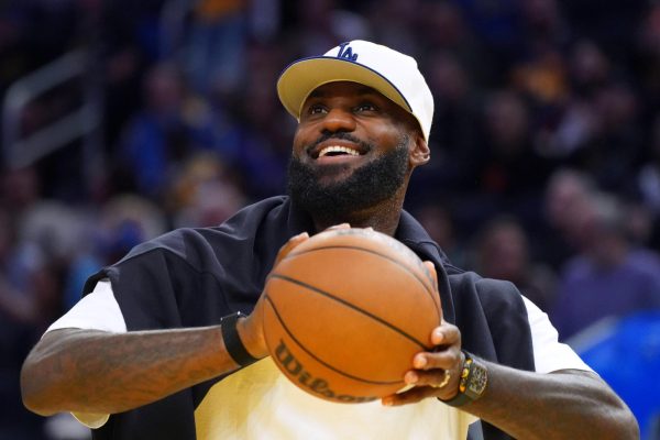 Oct 5, 2025; San Francisco, California, USA;  Los Angeles Lakers forward LeBron James (23), wearing a Los Angeles Dodgers hat, watches from the sideline during a break against the Golden State Warriors in the third quarter at Chase Center. Mandatory Credit: David Gonzales-Imagn Images