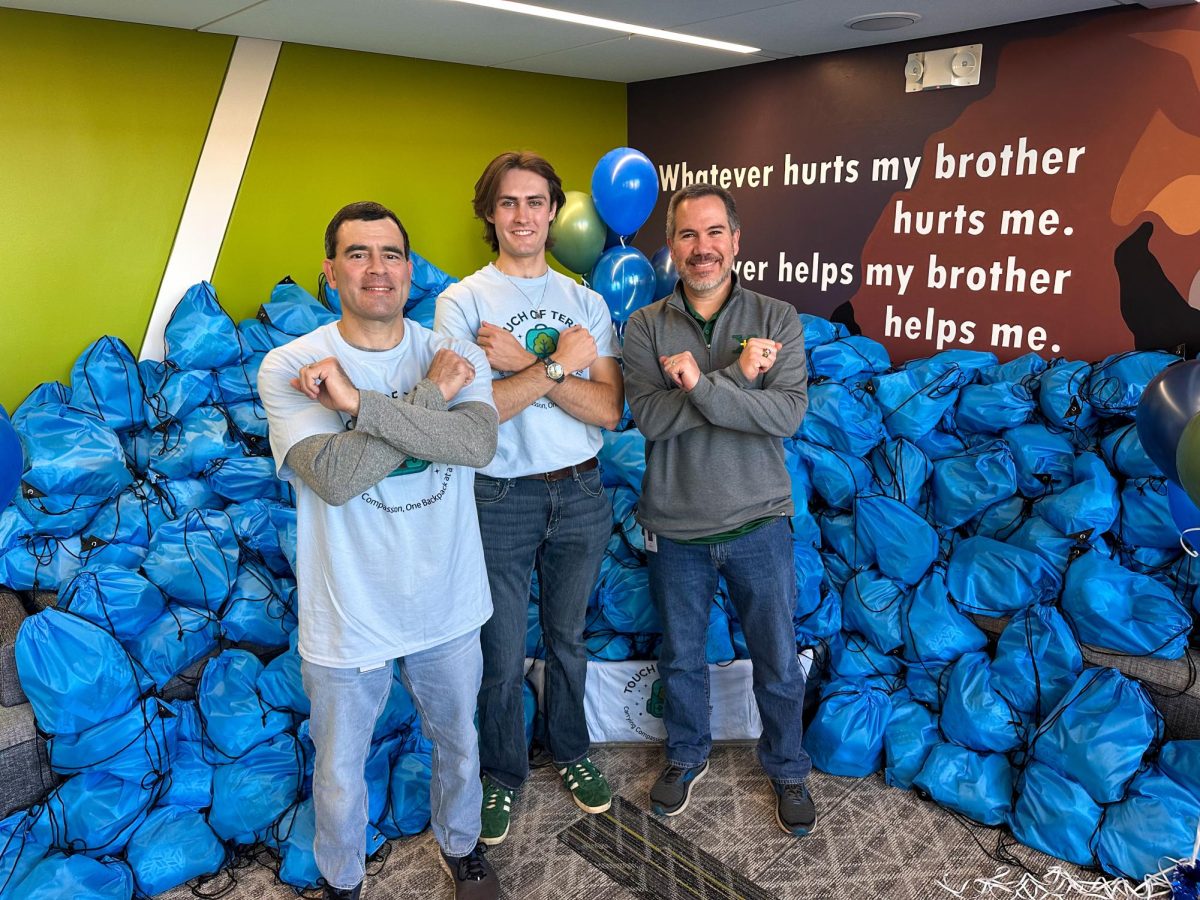 Coach Gold, DyLon Boone, and Dr. McCue in front of the bags they packed throughout the day
