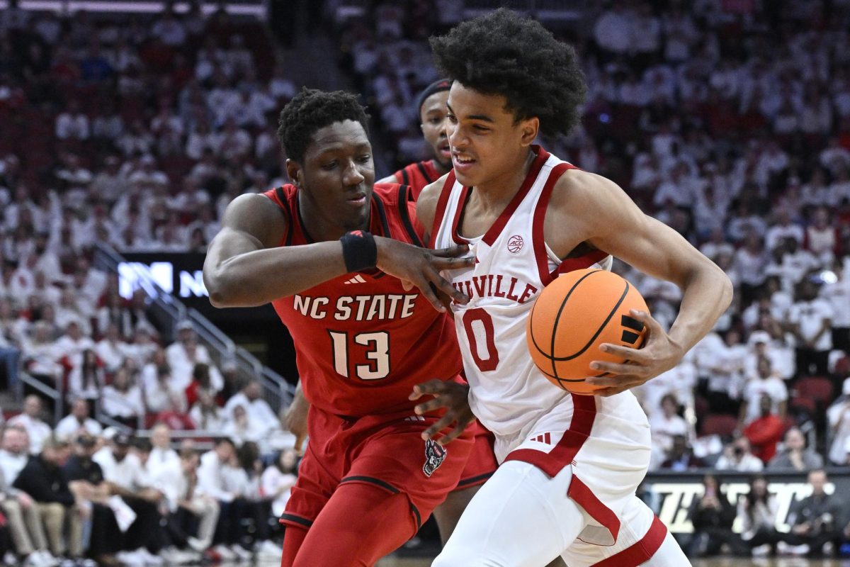Feb 9, 2026; Louisville, Kentucky, USA;  Louisville Cardinals guard Mikel Brown Jr. (0) drives to the basket against NC State Wolfpack forward Musa Sagnia (13) during the second half at KFC Yum! Center. Louisville defeated N.C. State 118-77.  Jamie Rhodes-Imagn Images