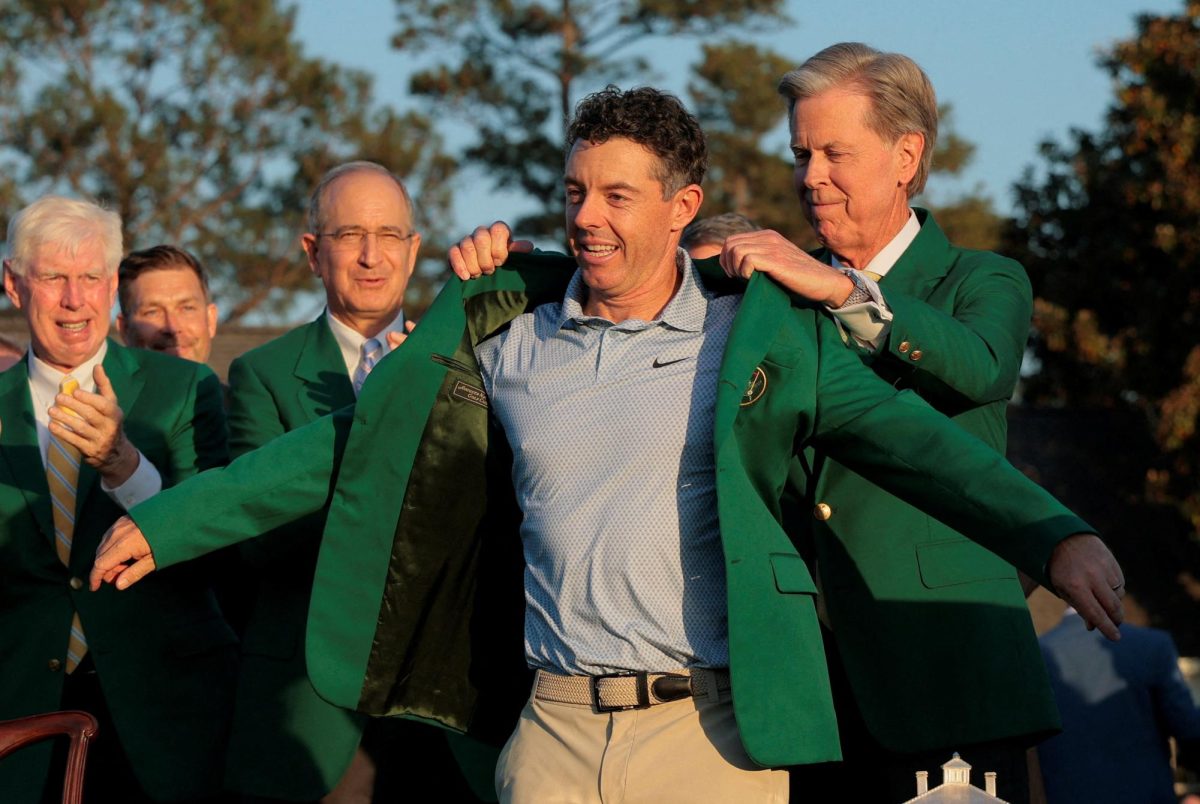 Golf - The Masters - Augusta National Golf Club, Augusta, Georgia, U.S. - April 12, 2026 Northern Ireland's Rory McIlroy is presented with the green jacket by Chairman of Augusta National Golf Club Fred Ridley after winning The Masters REUTERS/Brian Snyder